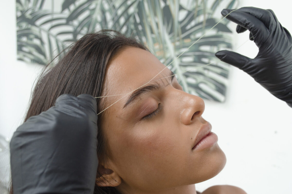 Mujer recibiendo un diseño de cejas con hilo en Samsara Madrid.